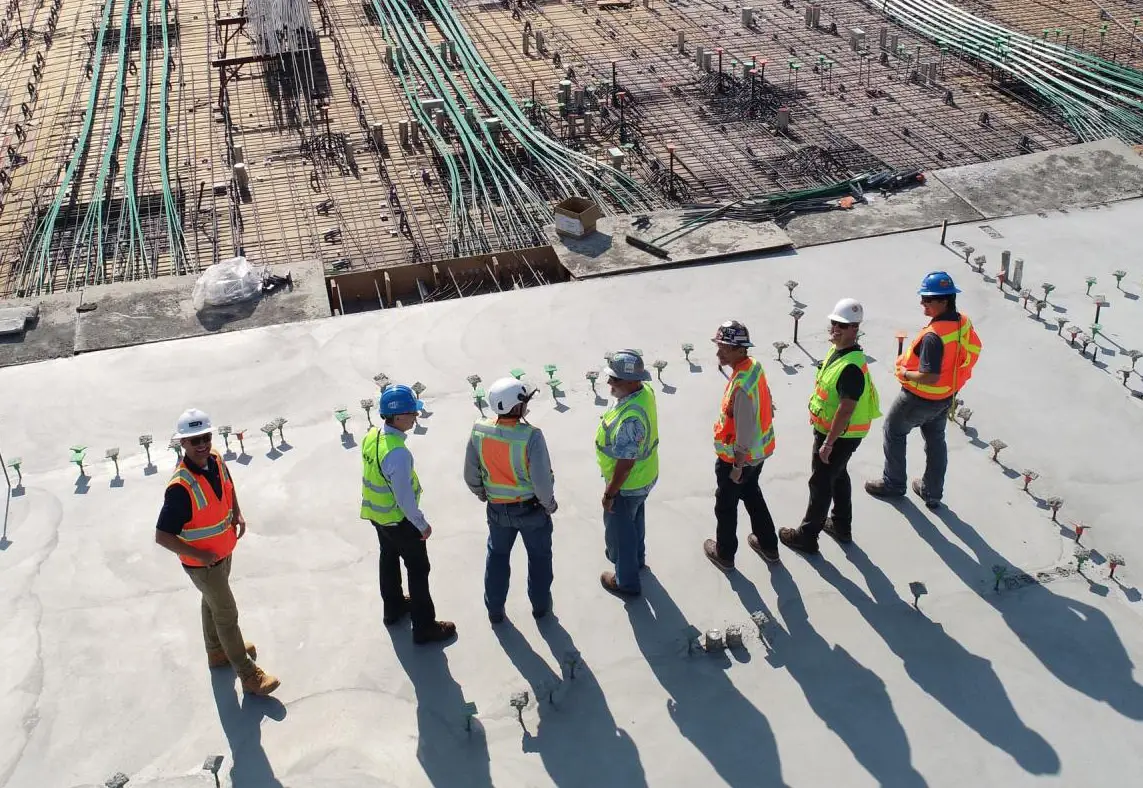 Men wearing helmets and reflective vests working on building construction